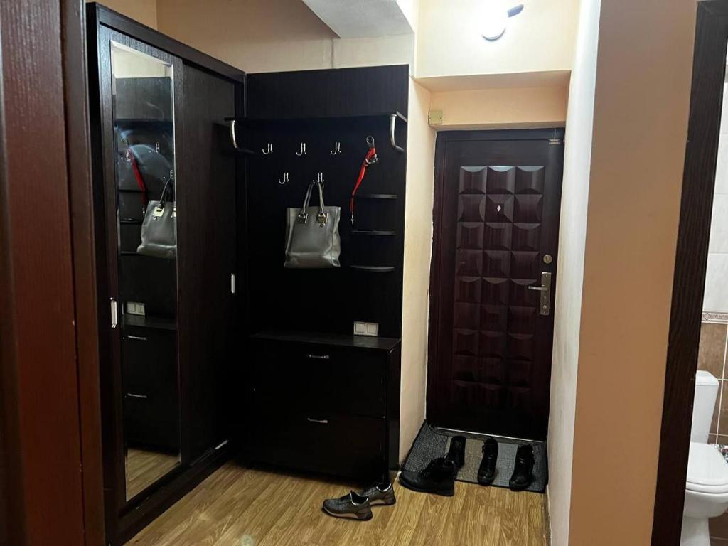 a closet with a black door and a pair of shoes at City Center Apartment in Tashkent