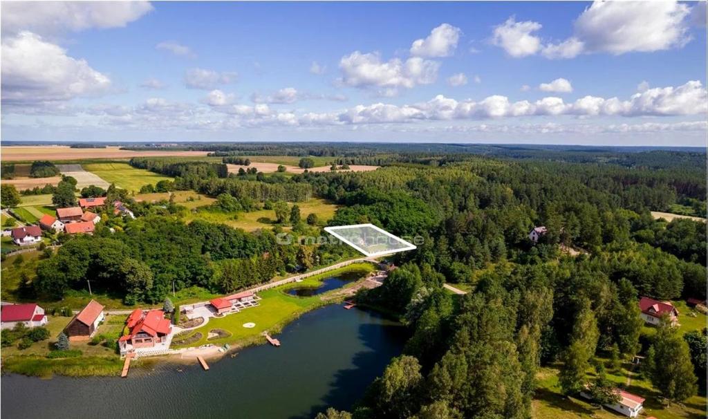 - une vue aérienne sur une maison avec solarium sur un lac dans l'établissement Domek na Skarpie Łutynowo gmina Olsztynek, à Olsztynek