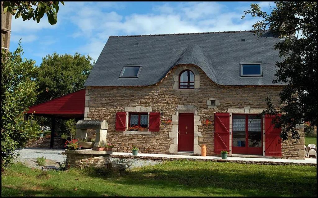 ein Backsteinhaus mit roten Türen und einem grauen Dach in der Unterkunft Maison de 4 chambres avec jardin amenage a Inzinzac Lochrist 