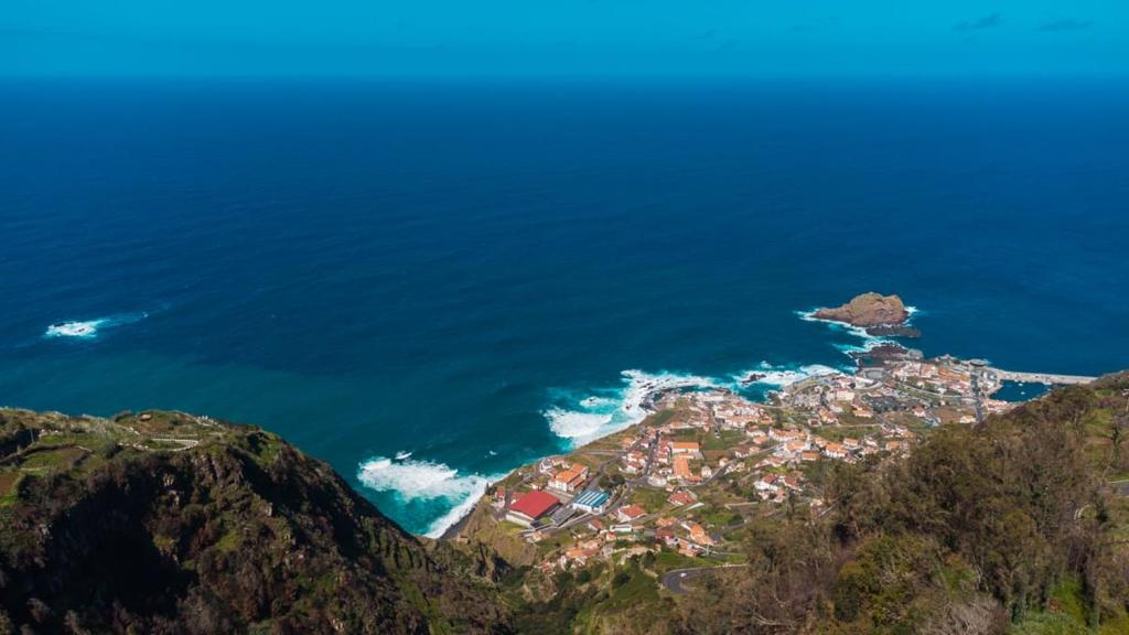 a town on the side of a mountain near the ocean at GuestReady - A typical vacation in Madeira in Porto Moniz