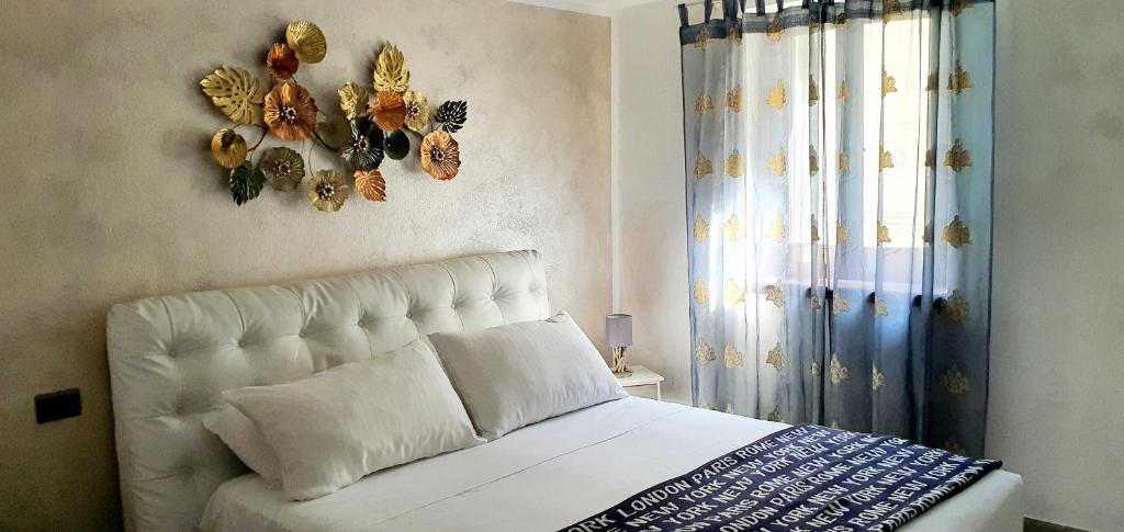 Un dormitorio con una cama blanca con mariposas en la pared. en La Petite - Certaldo, en Certaldo