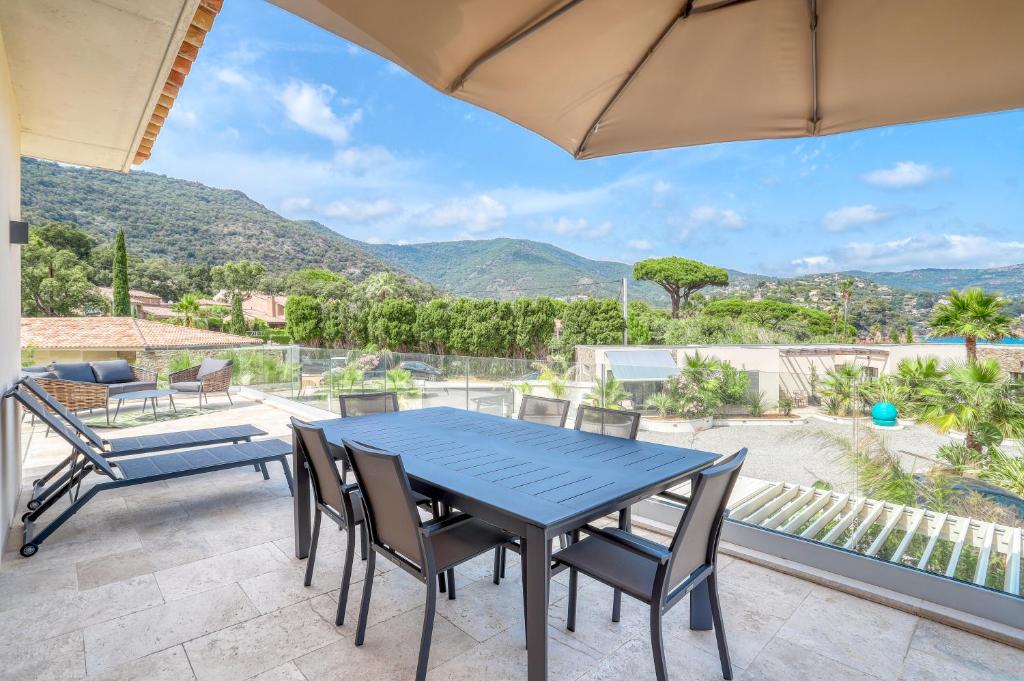 a blue table and chairs on a patio with a view at Akwabay - Les Villas du Cap in Le Lavandou