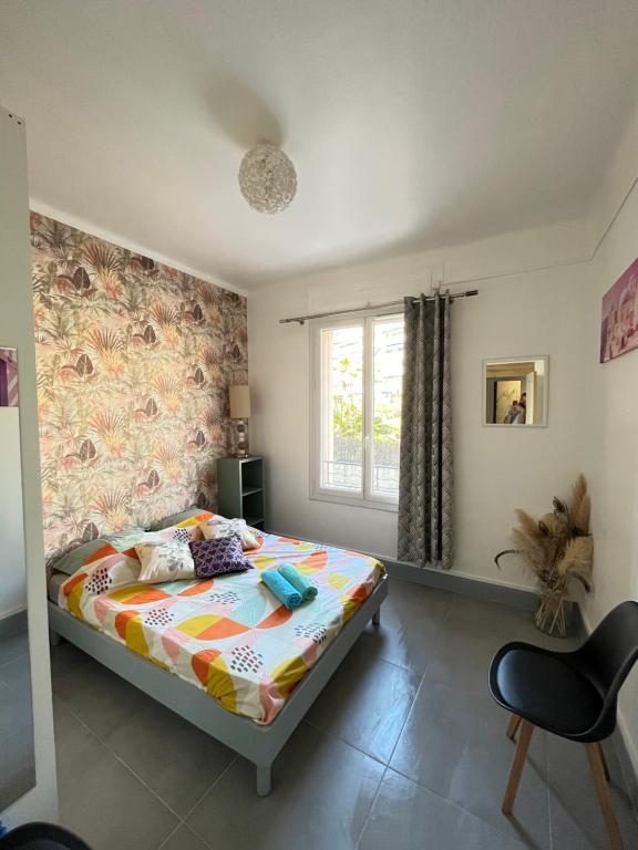 ein Schlafzimmer mit einem Bett und einem Fenster in der Unterkunft Appartement 3 pièces GREEN ART **** in Le Cannet
