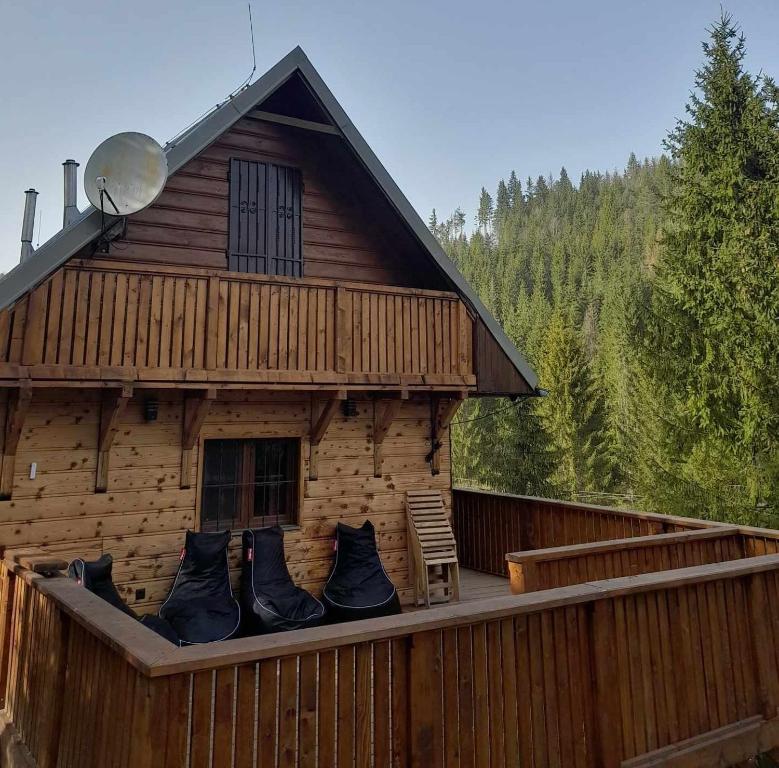 Cabaña de madera con terraza con silla en Chata Molik, en Lom nad Rimavicou