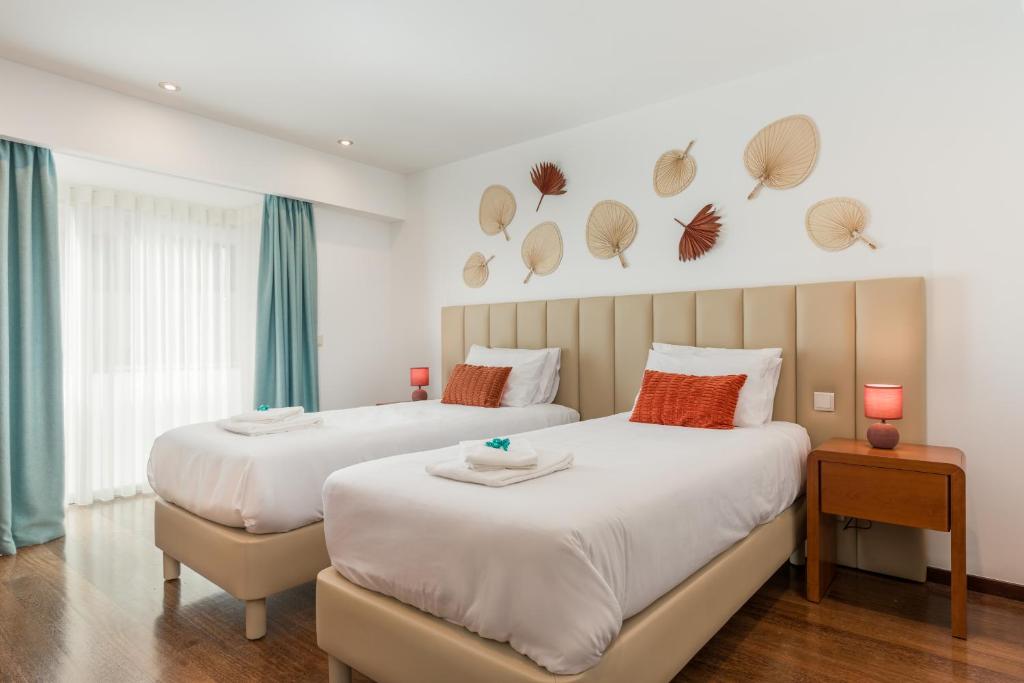 two beds in a hotel room with two beds at Viravento - Guesthouse & Creative Space in Espinho