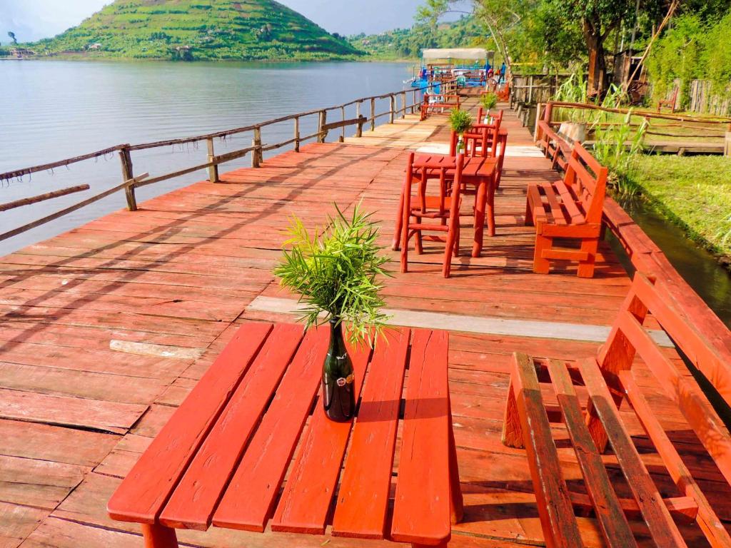 a row of wooden benches next to a body of water at Mutanda Eco Community Center in Kisoro