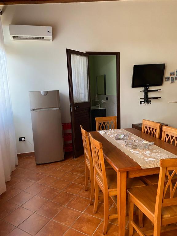 a dining room with a table and a refrigerator at Frichi house in Lampedusa