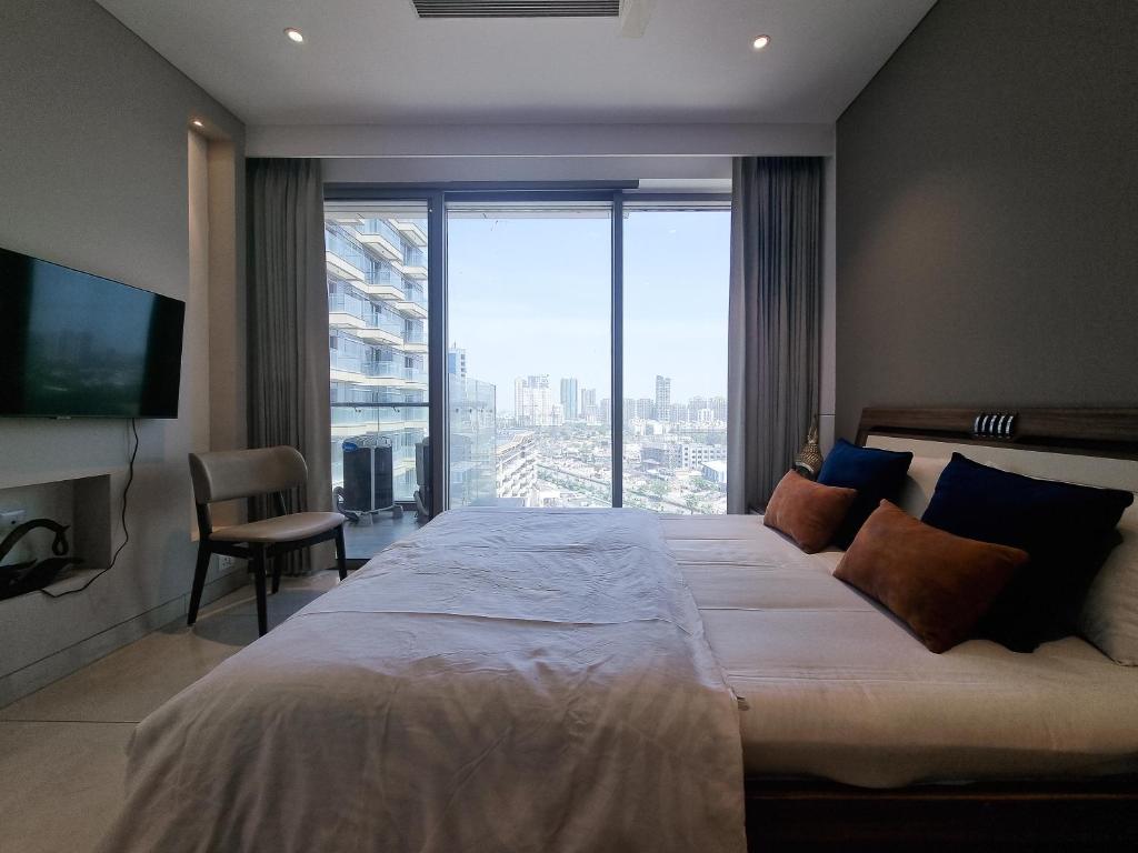 - une chambre avec un grand lit et une grande fenêtre dans l'établissement Luxury Studios Key 5 - 2 BHK Fully Furnished Apartment, à Gurgaon