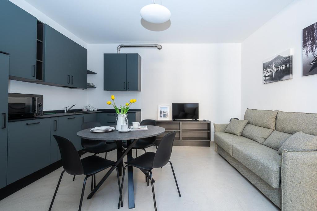 a kitchen and living room with a table and a couch at La Antica Cernobbio in Cernobbio