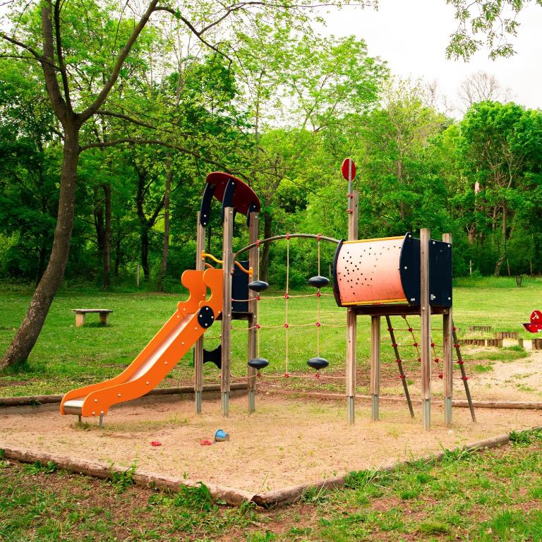 a playground in a park with a slide and a slideintend at The Hotel Unforgettable - Hotel Tiliana by Homoky Hotels & Spa in Budapest