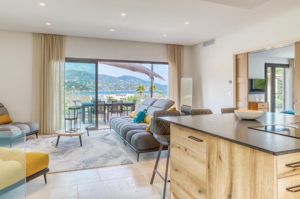 a kitchen and living room with a couch and a table at Akwabay - Les Villas du Cap in Le Lavandou