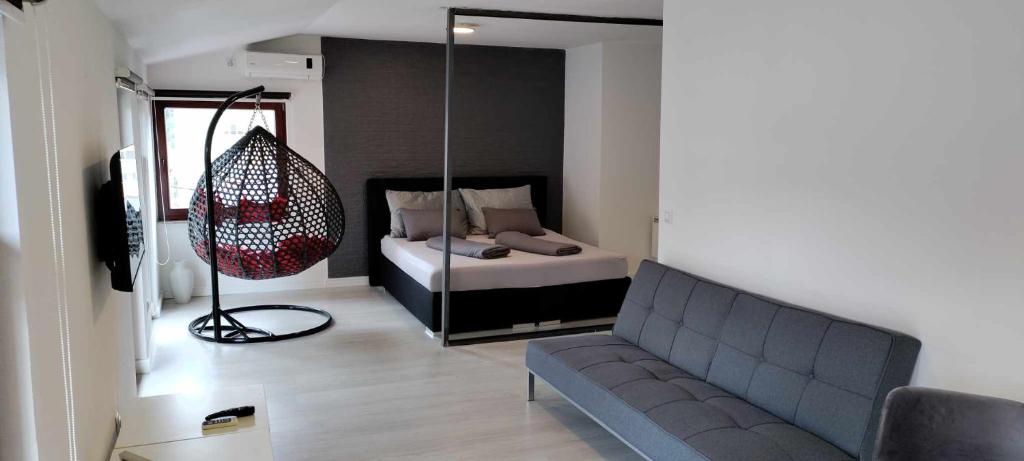 ein Wohnzimmer mit einem Sofa und einem Bett in der Unterkunft Apartmani Bujrum in Sarajevo