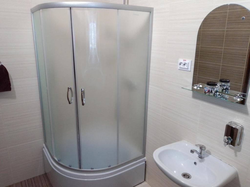 ein Bad mit einer Dusche und einem Waschbecken in der Unterkunft Hostel Iskra in Lwiw