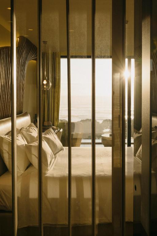 a bedroom with a bed and a window with a view at Vila Foz Hotel & SPA - member of Design Hotels in Porto
