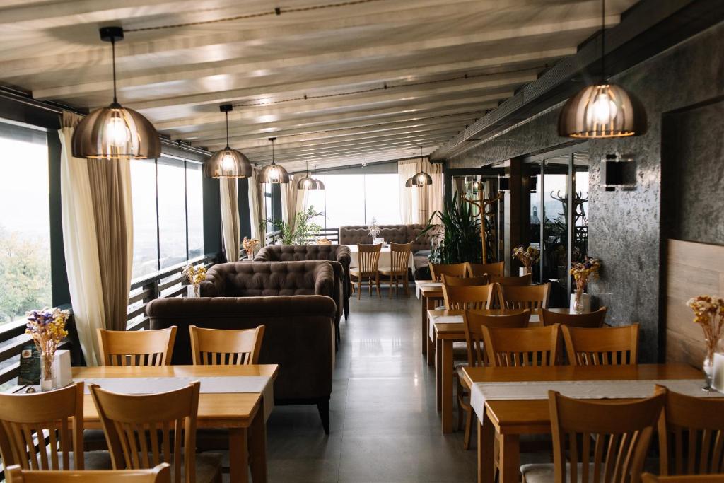 a restaurant with tables and couches and chairs at Готель Logindariy in Rokosovo