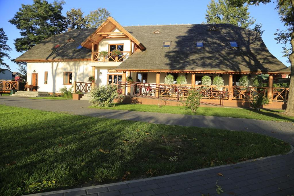 a house with a gambrel roof with a porch at Pensjonat Bajdarka in Suraż