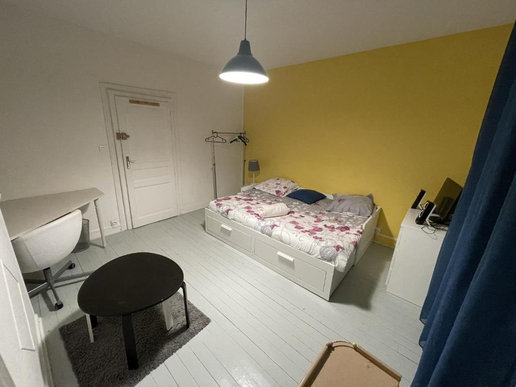 una camera con letto, scrivania e sedia di Bienvenu chez Zazou a Limoges