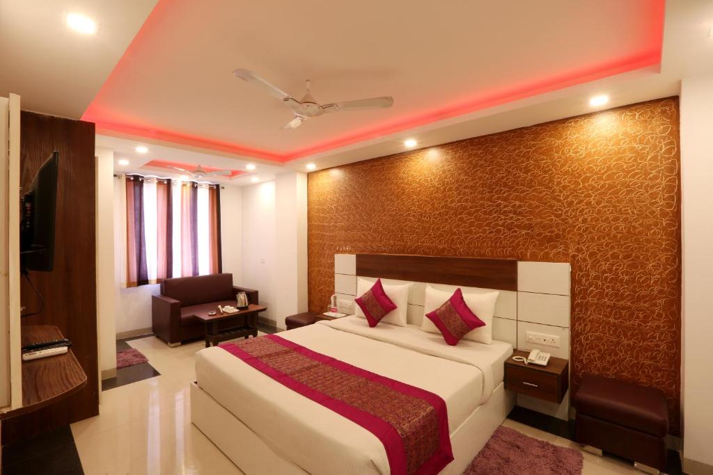 a hotel room with a bed and a chair at Hotel Sky Wood At Airport in New Delhi