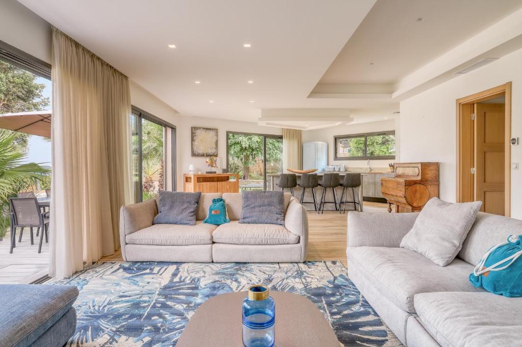 a living room with two couches and a kitchen at Akwabay - Les Villas du Cap in Le Lavandou