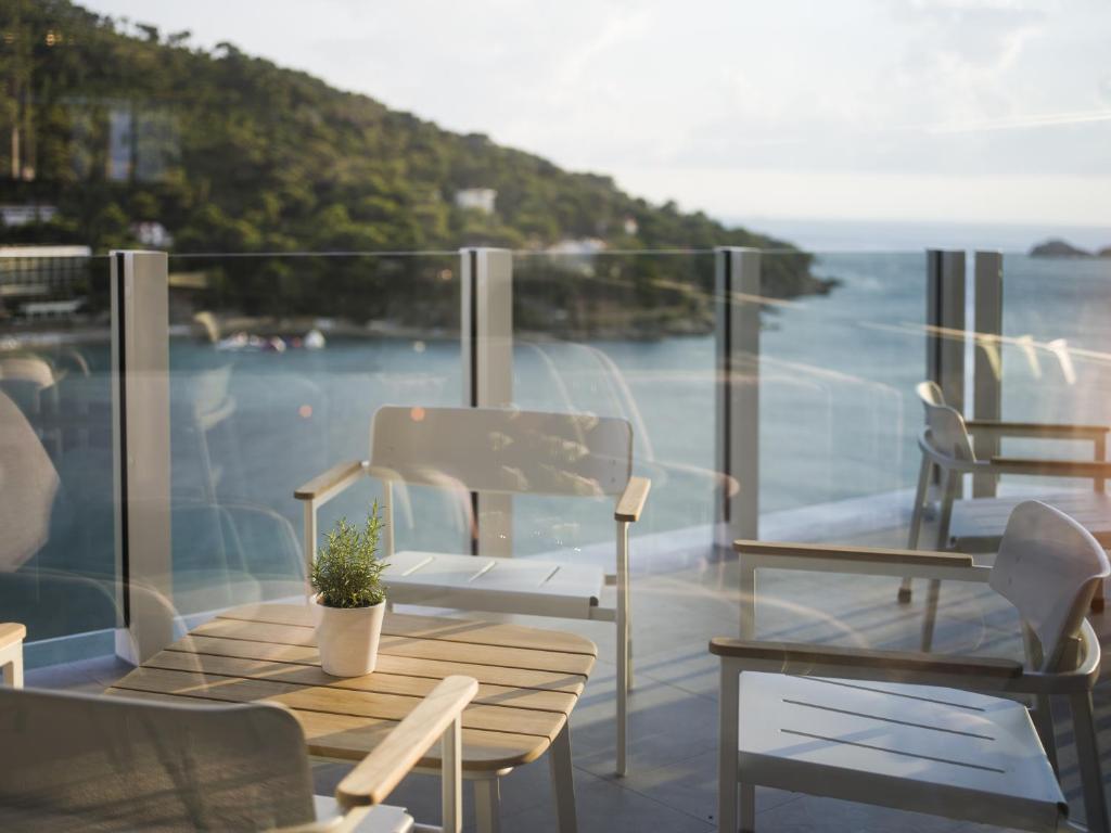 a balcony with a table and chairs and a view of the ocean at Hotel Kompas in Dubrovnik