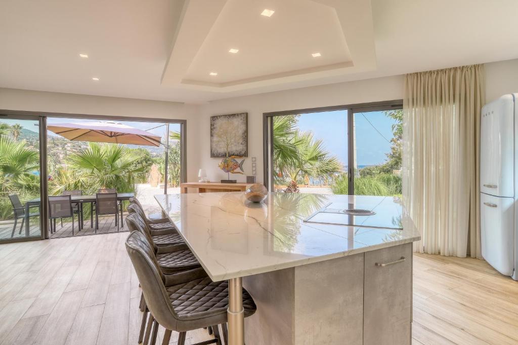 a kitchen with a large island with chairs and a counter top at Akwabay - Les Villas du Cap in Le Lavandou
