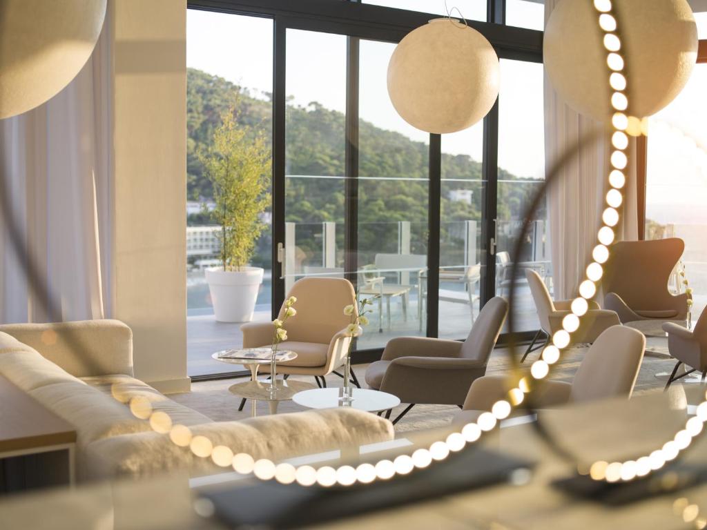 a waiting room with couches and chairs and a large window at Hotel Kompas in Dubrovnik