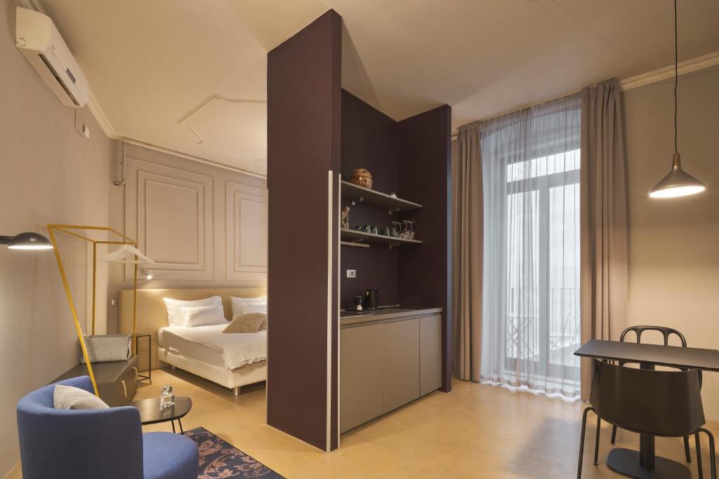 um quarto com uma cama e um quarto com uma mesa em URBANAUTS BELETAGES Sonata em Trieste