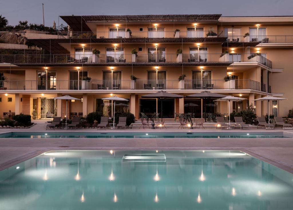 a hotel with a pool in front of a building at Luna Minoica Suites and Apartments in Montallegro