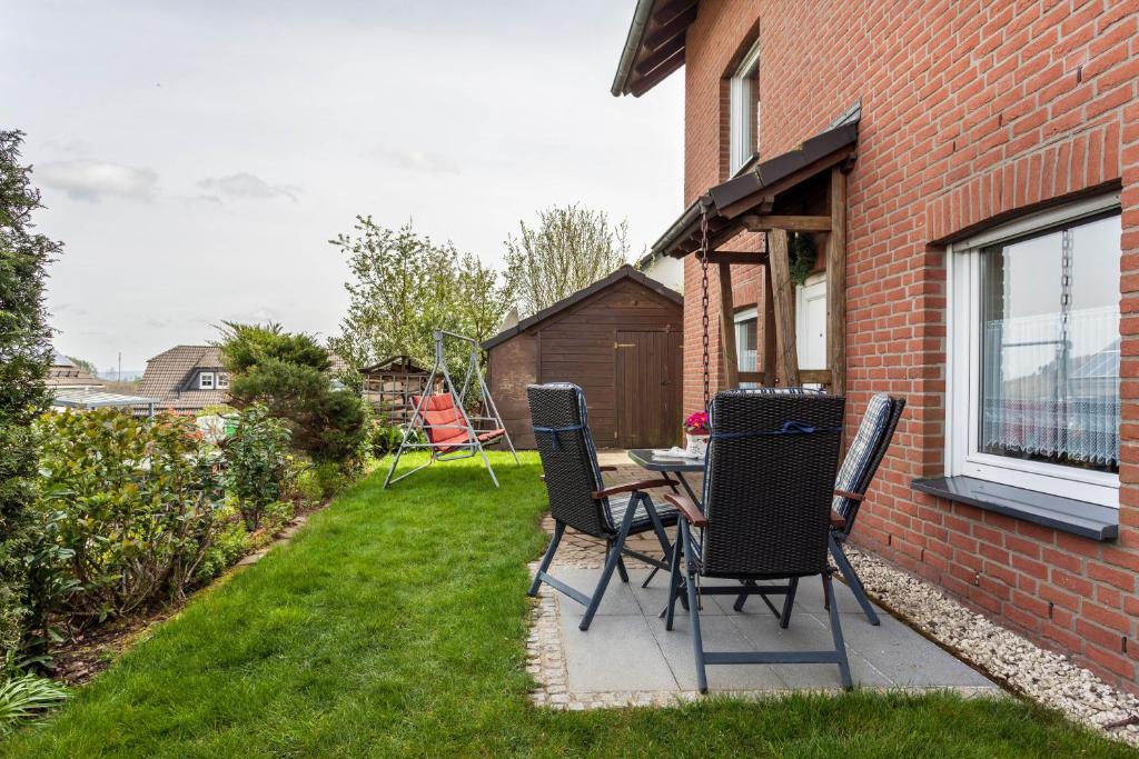 eine Terrasse mit Stühlen und einem Tisch im Hof in der Unterkunft Ferienwohnung Am Wald in Herscheid