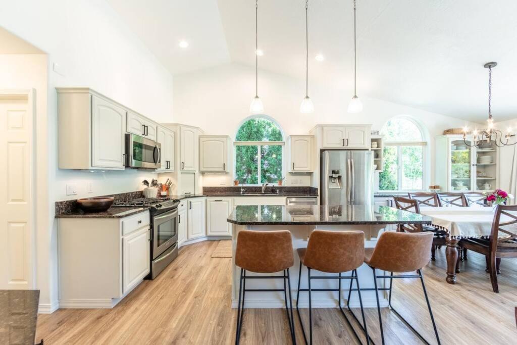 a kitchen with white cabinets and a table and chairs at Big Family Getaway- Theater Room- BBQ- Play Room- Fire Pit in Coeur d'Alene