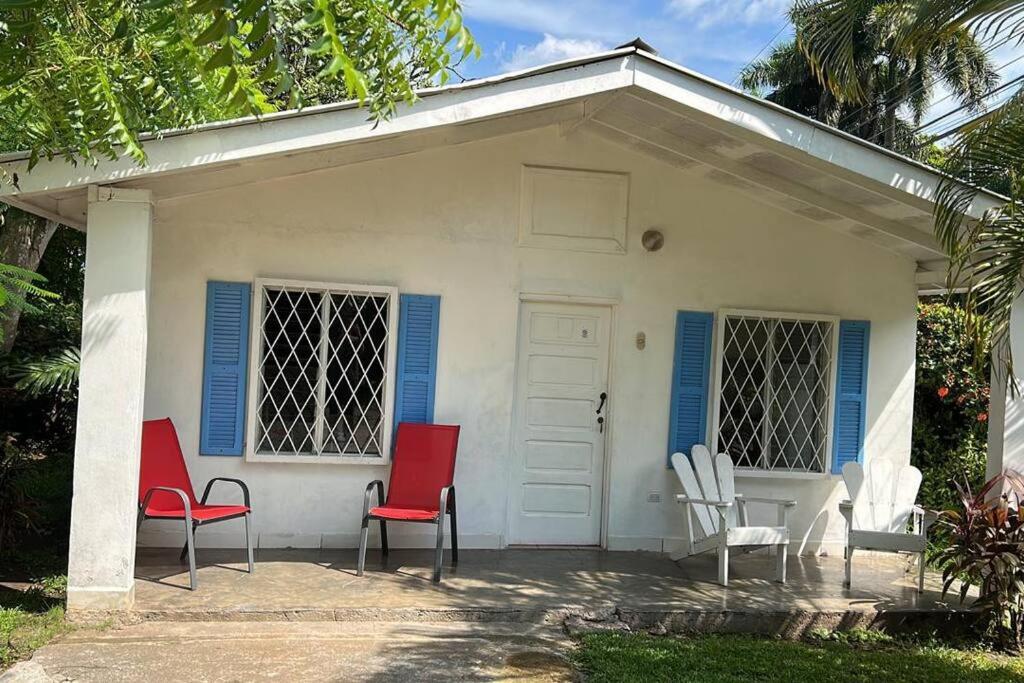 uma casa branca com cadeiras vermelhas e brancas em frente em Villa 8 personas em Puntarenas