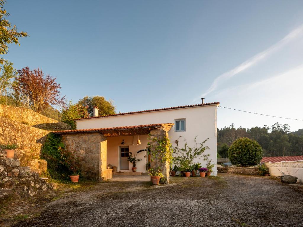 a small white house with a stone wall at Doni Beach House in A Coruña