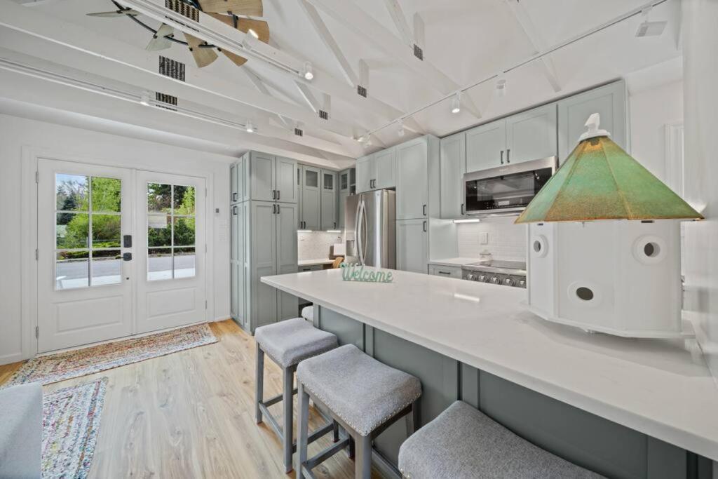 a kitchen with white cabinets and a large counter with stools at Private Cottage on Annie in Coeur d'Alene