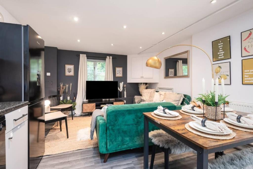 un soggiorno con divano verde e tavolo di Well Located Stylish 5 Bed House a Kent