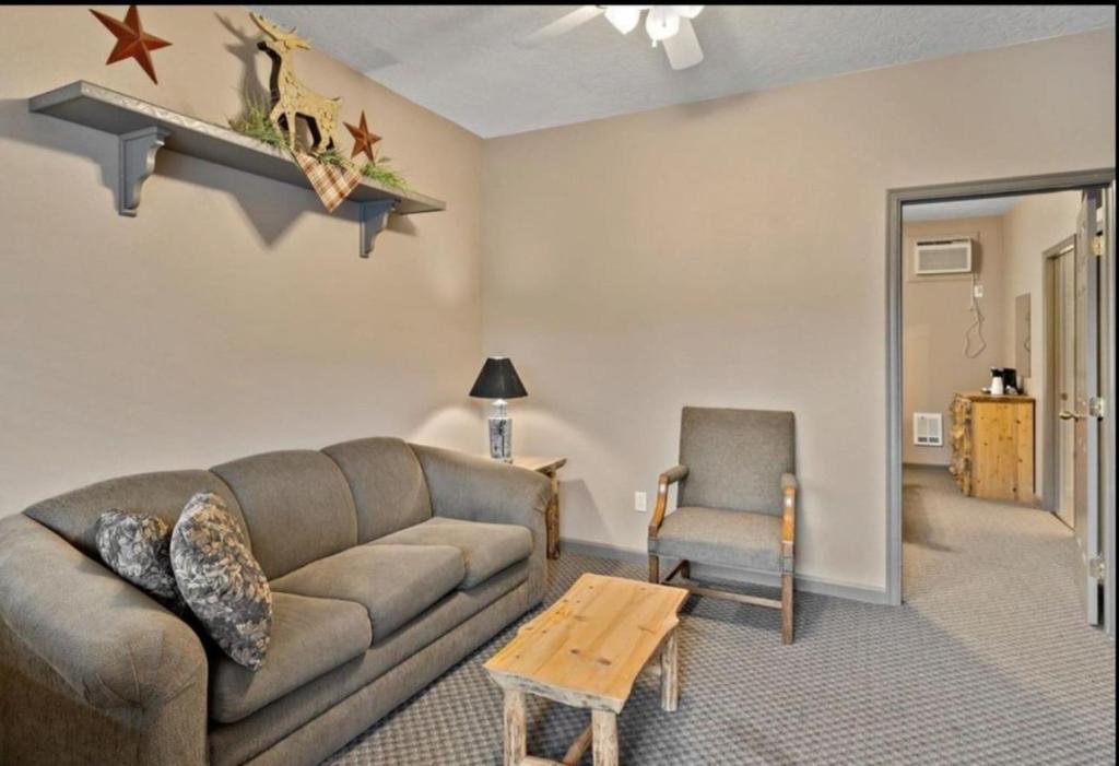 ein Wohnzimmer mit einem Sofa und einem Stuhl in der Unterkunft Queen Suite Ensuite at Southfork Lodge Motel in Lowman