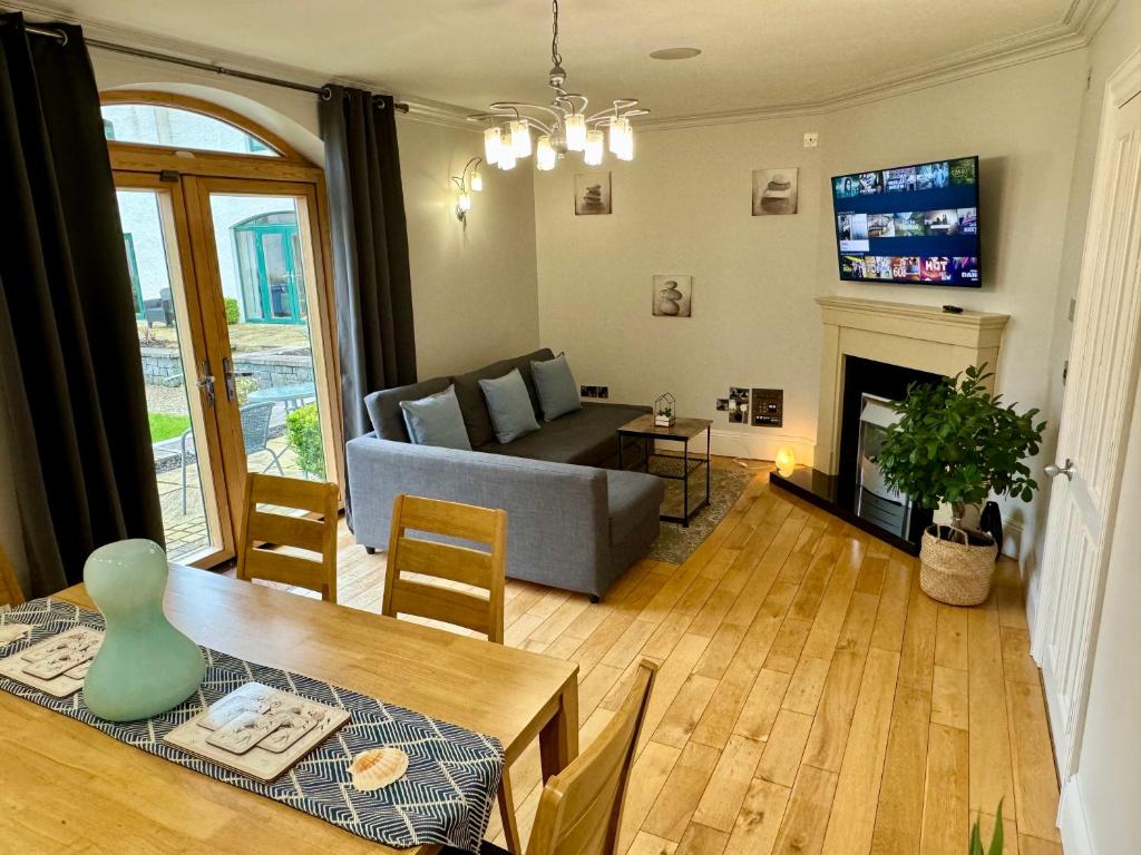 a living room with a table and a couch and a fireplace at 3 Castle Hume Court Holiday House in Enniskillen