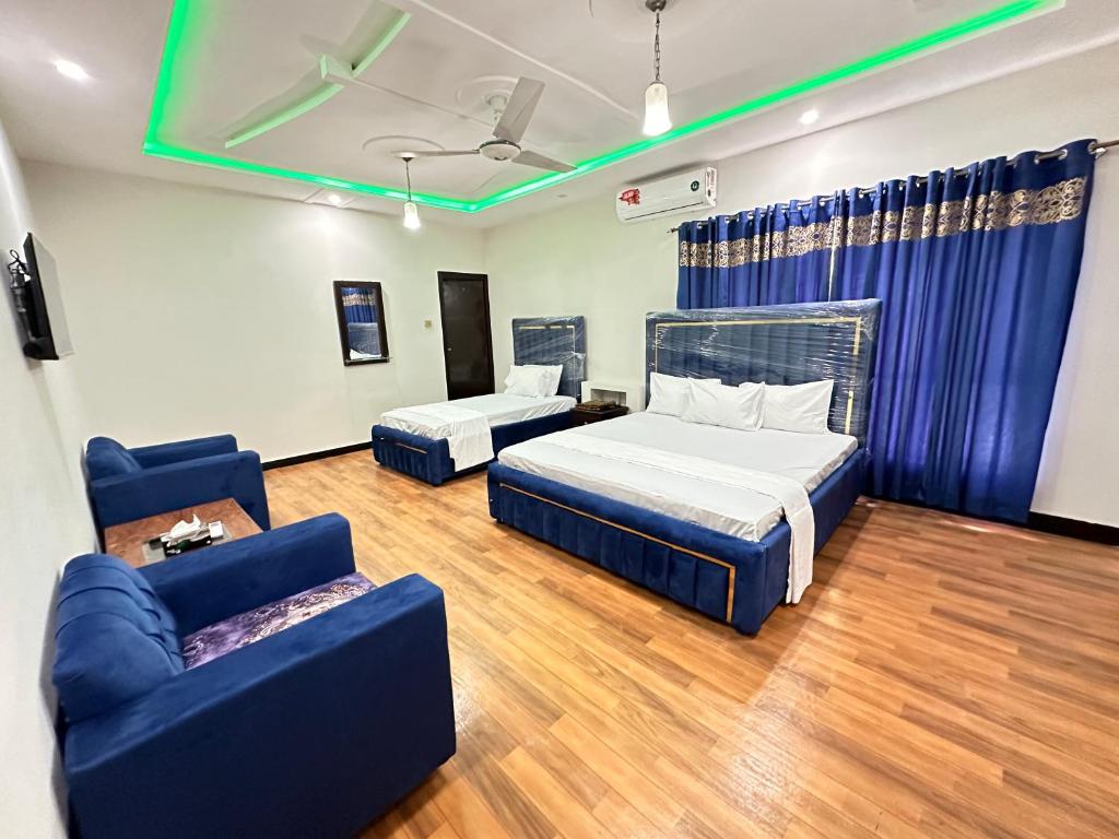 a room with two beds and a couch in it at Decent Lodge Guest House in Islamabad