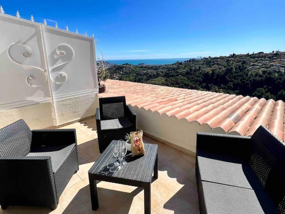 un patio avec des chaises et une table sur un toit dans l'établissement Charmante maison de village, à Falicon