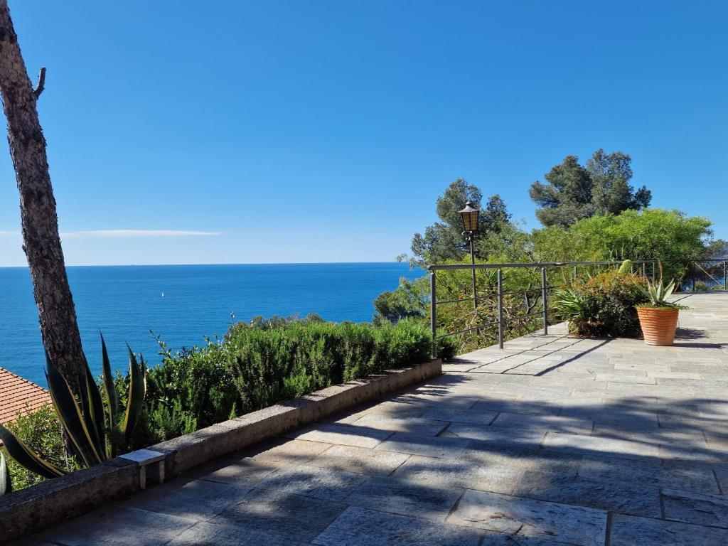 a walkway with the ocean in the background at Appartamento in Villa Mimosa in Cervo
