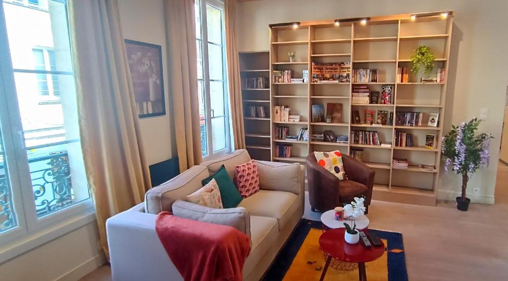 un salon avec un canapé et une étagère dans l'établissement Appartement de Style - Rue Piétonne - Centre Ville, à Caen