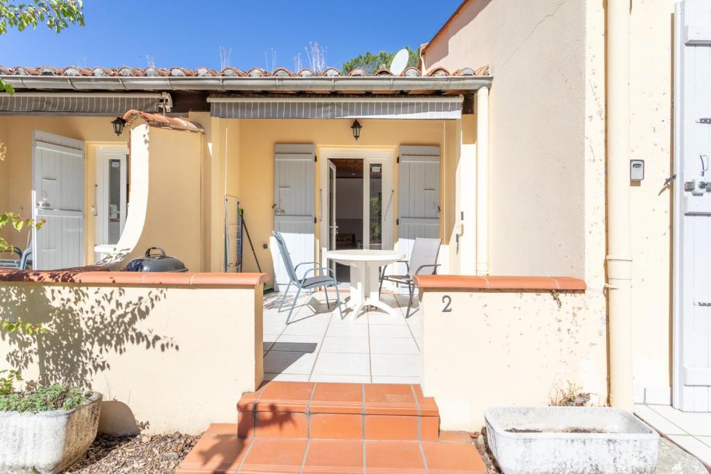 une terrasse avec une table et des chaises dans une maison dans l'établissement Gite 2 entre 2 et 4 personne, à Reynès