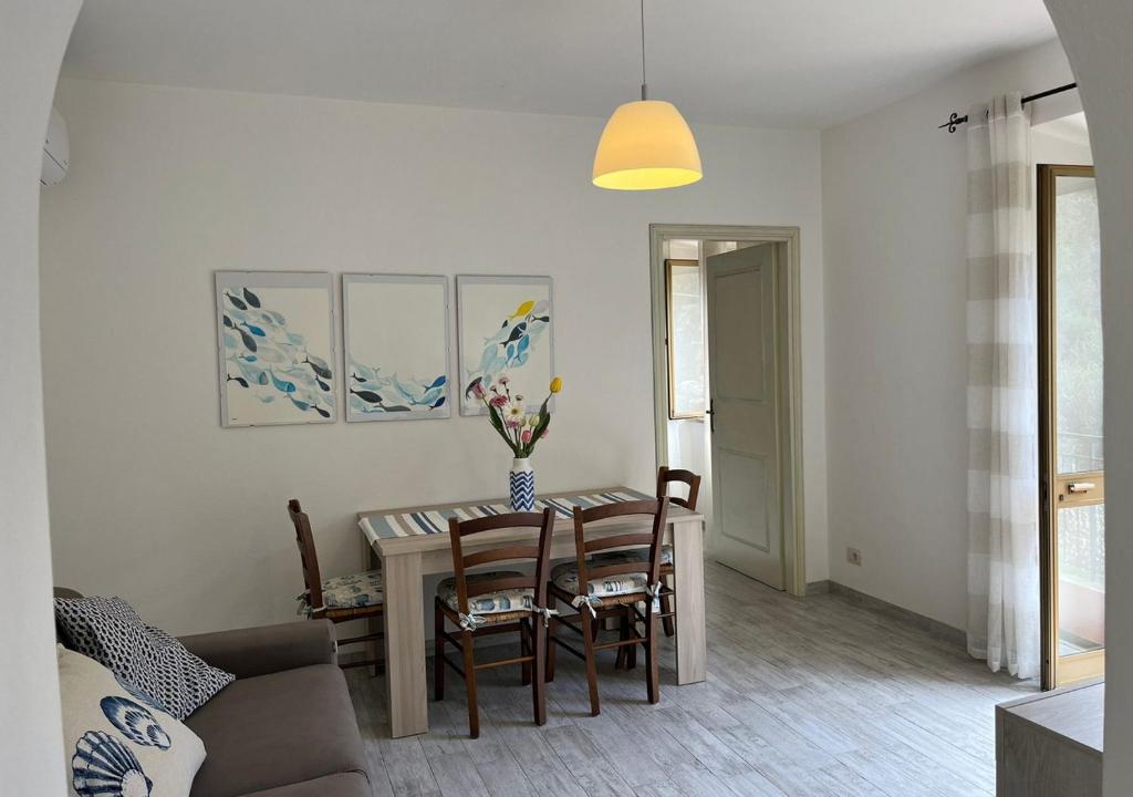 uma sala de estar com mesa e cadeiras em Casa degli Ulivi em Porto Santo Stefano