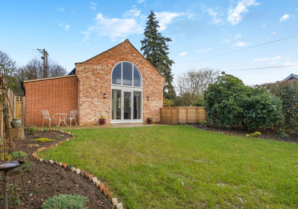 a brick house with a lawn in front of it at The Old Chapel - Tasburgh in Ashwellthorpe