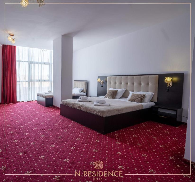- une chambre avec un grand lit et un tapis rouge dans l'établissement HOTEL N Residence, à Timişoara