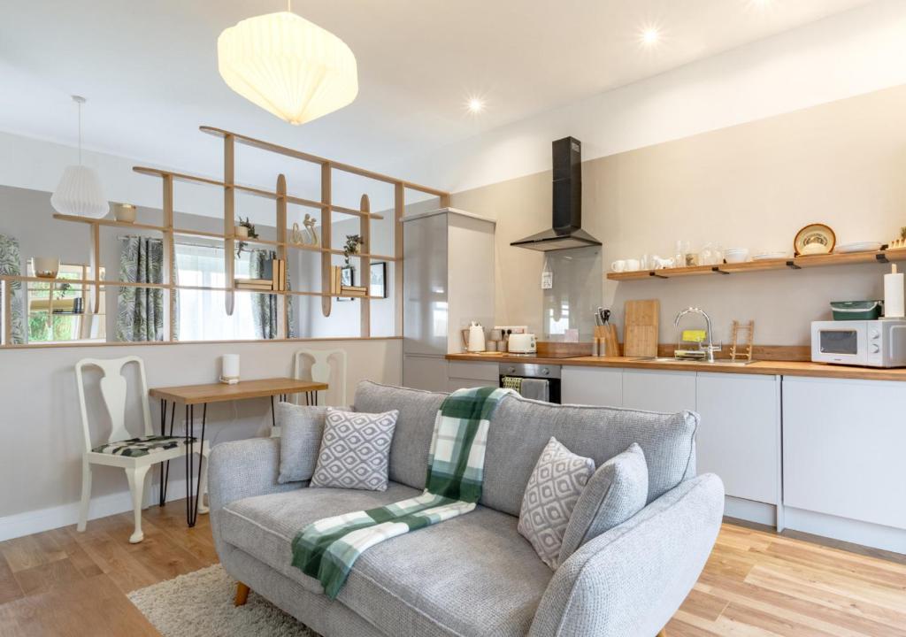 Little Oldbury في Hevingham: غرفة معيشة مع أريكة ومطبخ