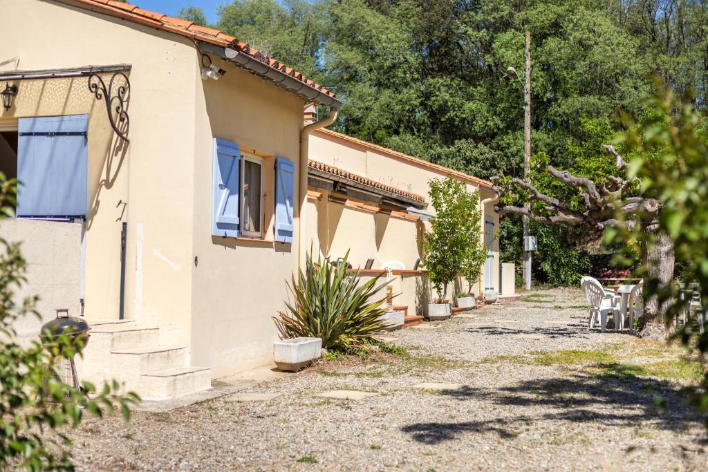 une maison avec un chemin à côté d'un bâtiment dans l'établissement Gite 1 entre 4 et 6 personnes, à Reynès
