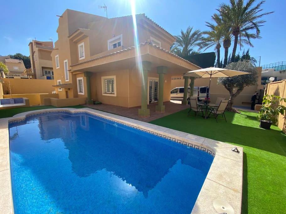 une villa avec une piscine en face d'une maison dans l'établissement Villa Benidorm Levante Beach, à Benidorm