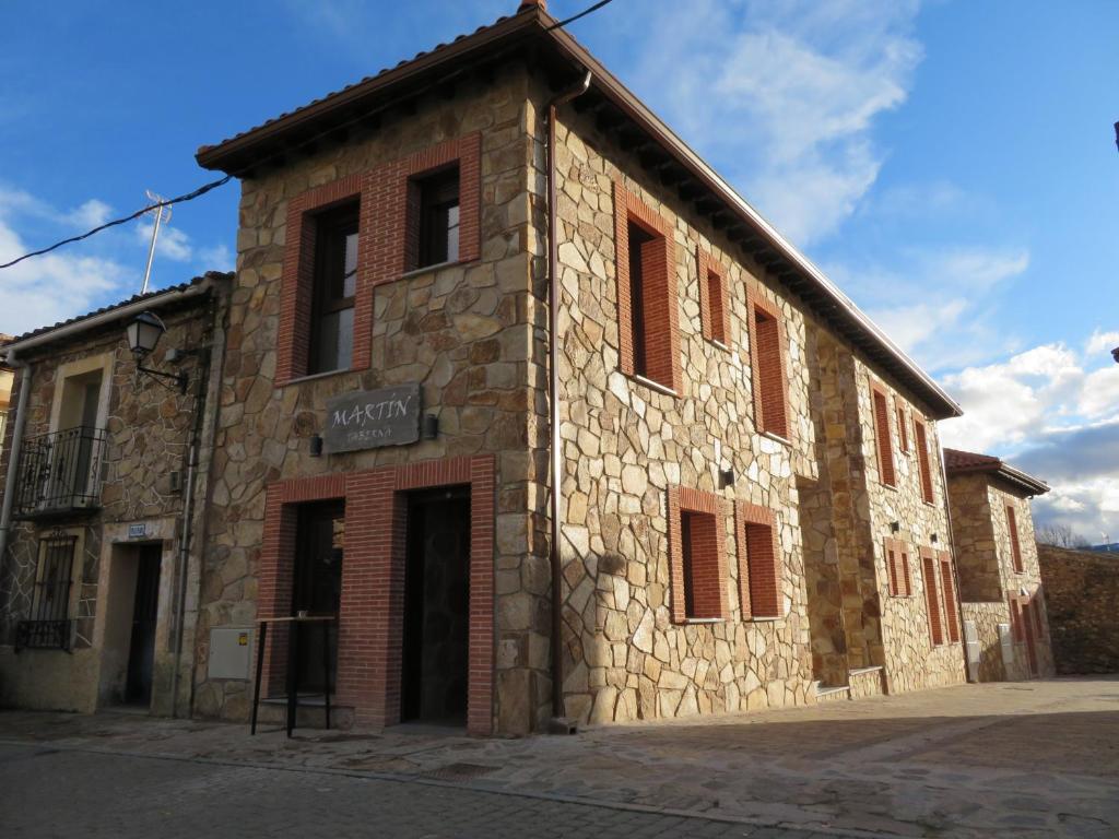 an old stone building on a street at Martín Taberna in Villavieja del Lozoya