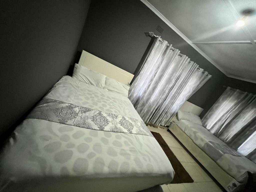 um pequeno quarto com uma cama e uma janela em Golden bamboo em Masvingo