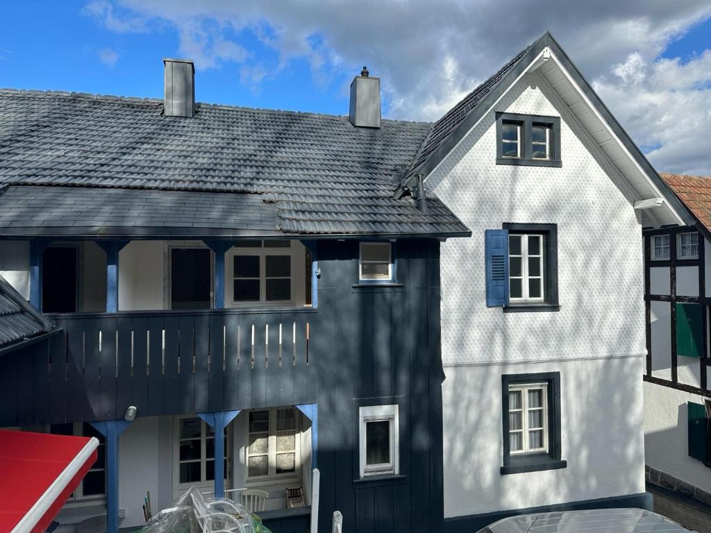 una casa blanca con techo negro en Ferienhaus Bühlertal mit 3 Fewos, en Bühlertal